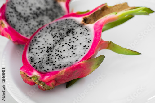 Dragon fruit. Vibrant Dragon Fruit on white background. Sliced white dragon fruit or pitaya on white plate on the table, close-up. Tropical and exotic fruits. Healthy and vitamin food concept.