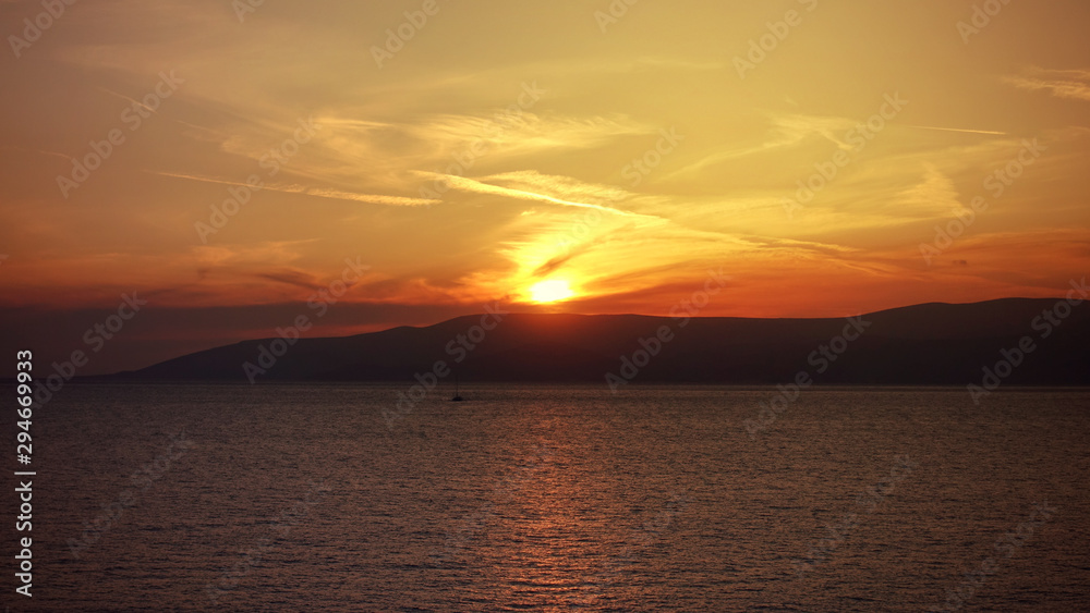 Photo of beautiful cloudy sunset with golden colours over the Aegean sea