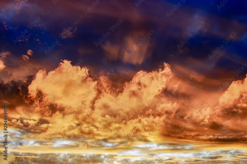 Naklejka premium Dramatic sky at sunset or sunrise with red and orange clouds. Variegated colored clouds at the evening sunset of the summer sky.