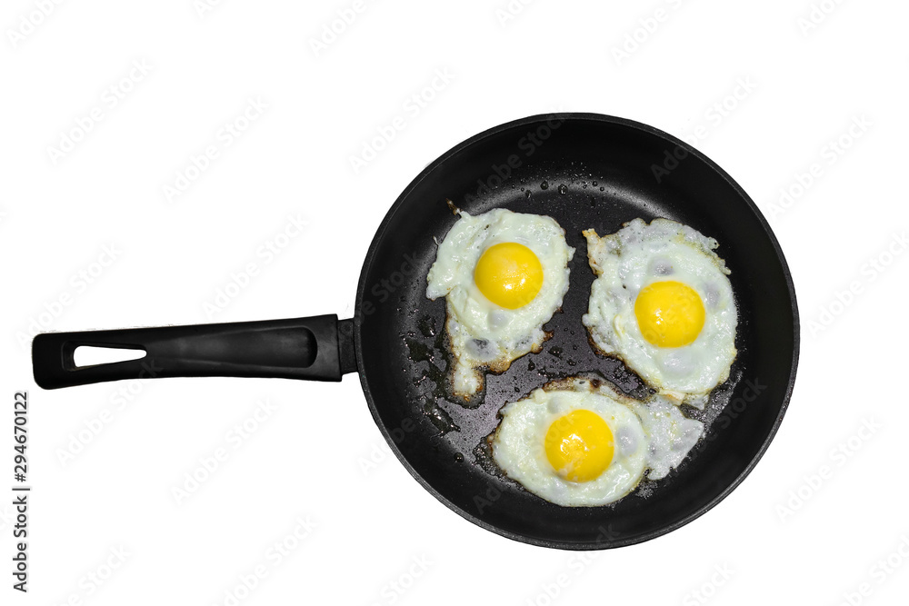 Three fried eggs in a cast iron frying pan isolated on white background. Concept of fast and healthy breakfast, top view Three fried eggs in a cast iron frying pan isolated on white background. Concept of fast and healthy breakfast, top view