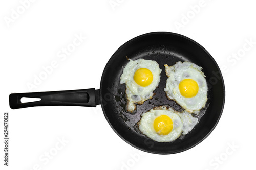 Three fried eggs in a cast iron frying pan isolated on white background. Concept of fast and healthy breakfast, top view