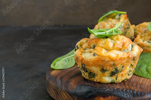 homemade cheese muffins with spinach. on dark background.