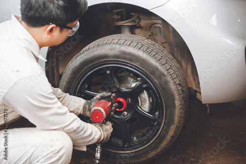 Mechanician changing car wheel in auto repair shop © nikomsolftwaer