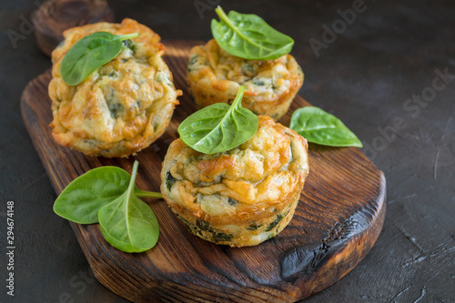 homemade cheese muffins with spinach. on dark background.