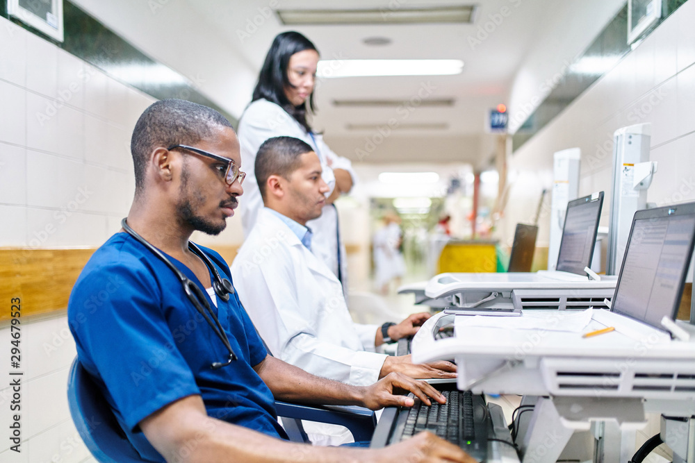 © Per Swantesson/Stocksy - Three doctors doing administrative work