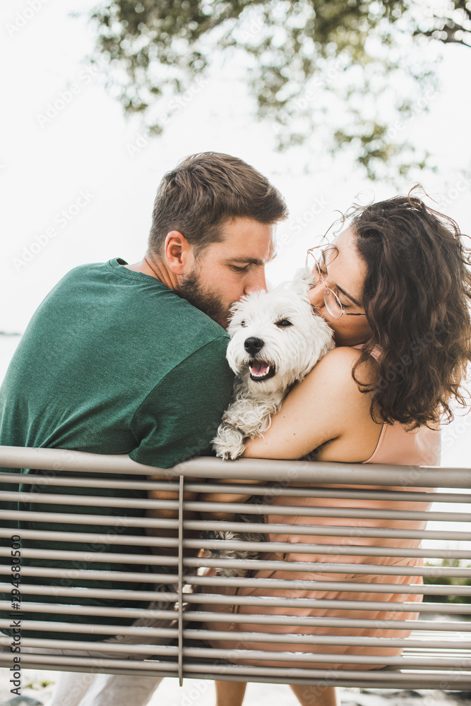 Couple sitting on the bench with the dog