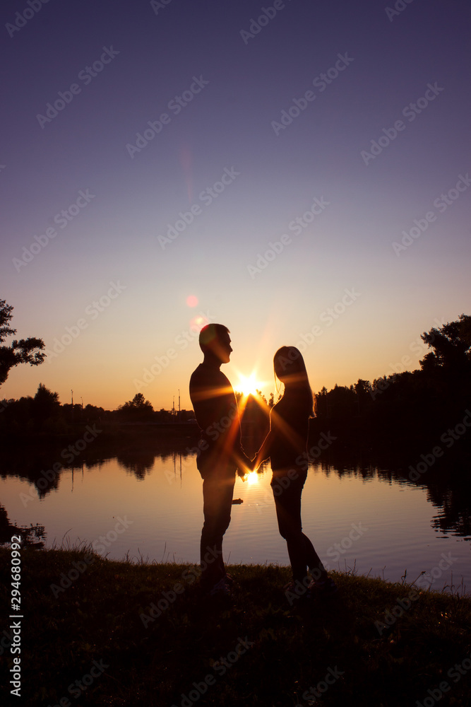 Silhouette of couple on the beach looking at sunrise. Silhouette of couple on the beach looking at sunrise.