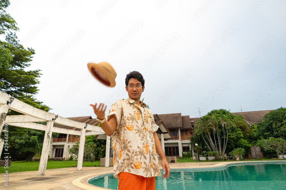 Fototapeta premium A man throwing a hat at the pool
