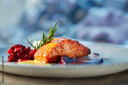 Fototapeta Naklejka Na Ścianę i Meble -  Closeup of piece of red salmon served with fruit garnish