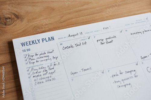 Overhead shot of a weekly planner on a wooden desk
