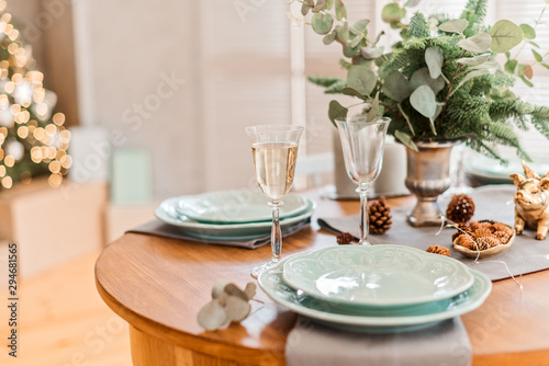 Festive christmas table with plate and glasses with champagne
