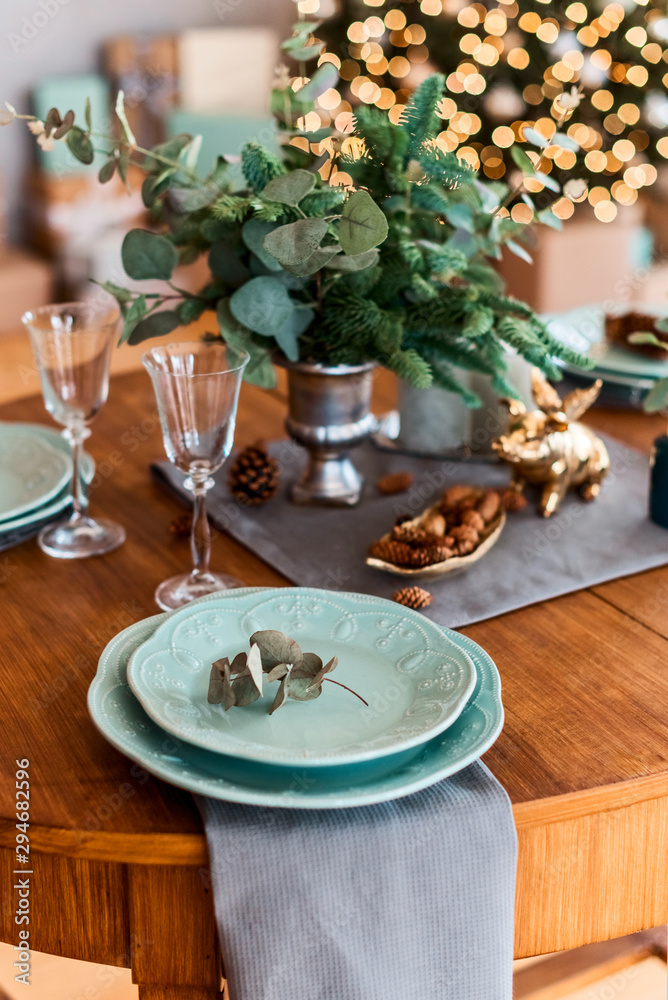 Christmas table with table setting with glass, pine corn and green