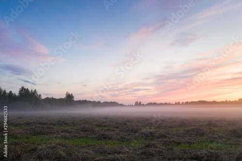 Magnificent sunset and mist spreading across the field, Leningrad region, Russia