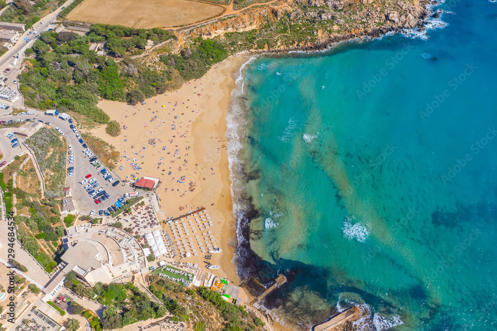 Aerial vew from fying drone view of the wild beach with sunbathers resting people.