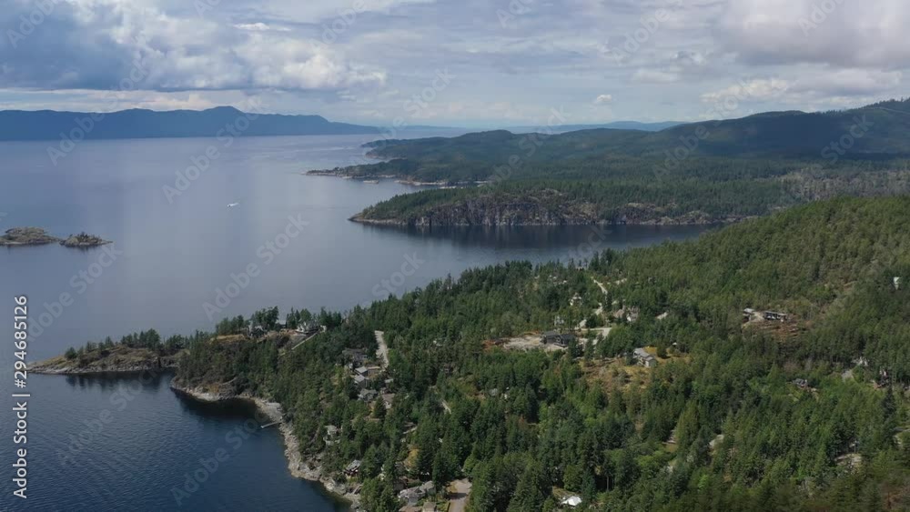 Aerial view over inlet, ocean and island with boat and mountains in beautiful British Columbia. Canada. 4K. Aerial view over inlet, ocean and island with boat and mountains in beautiful British Columbia. Canada. 4K.