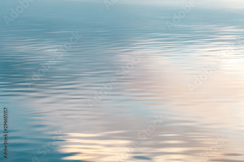 Sunrise reflected against the surface of a calm lake