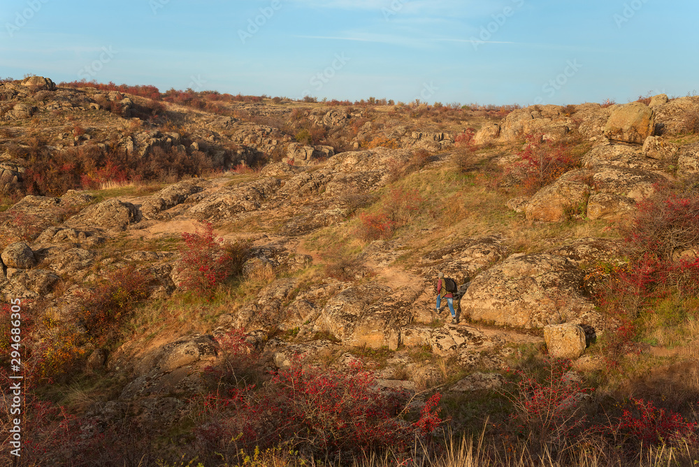 Obraz premium Bactive, active rest, activity, adult, adventure, autumn, background, backpack, bearded man, canyon, clack of an old male tourist with a gray beard against the backdrop of mountains, rocks and forests