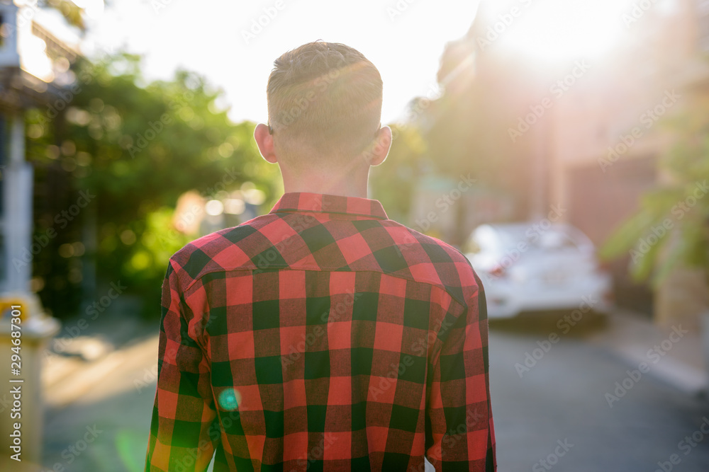Fototapeta premium Young man wearing red checkered shirt in the streets outdoors