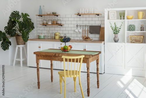 Light white kitchen in modern style with yellow wood chair and wood table