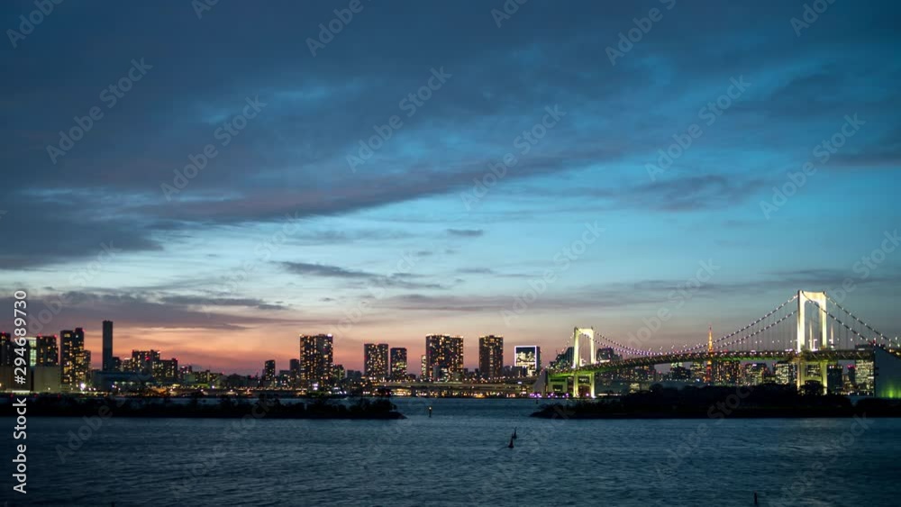 Amazing timelapse of Tokyo skyline with Rainbow Bridge and Tokyo bay at evening after sunset Amazing timelapse of Tokyo skyline with Rainbow Bridge and Tokyo bay at evening after sunset