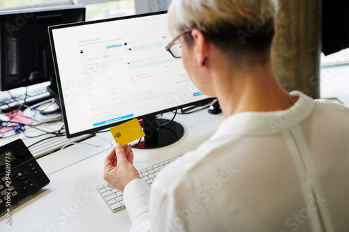 Mature woman entering credit card credential