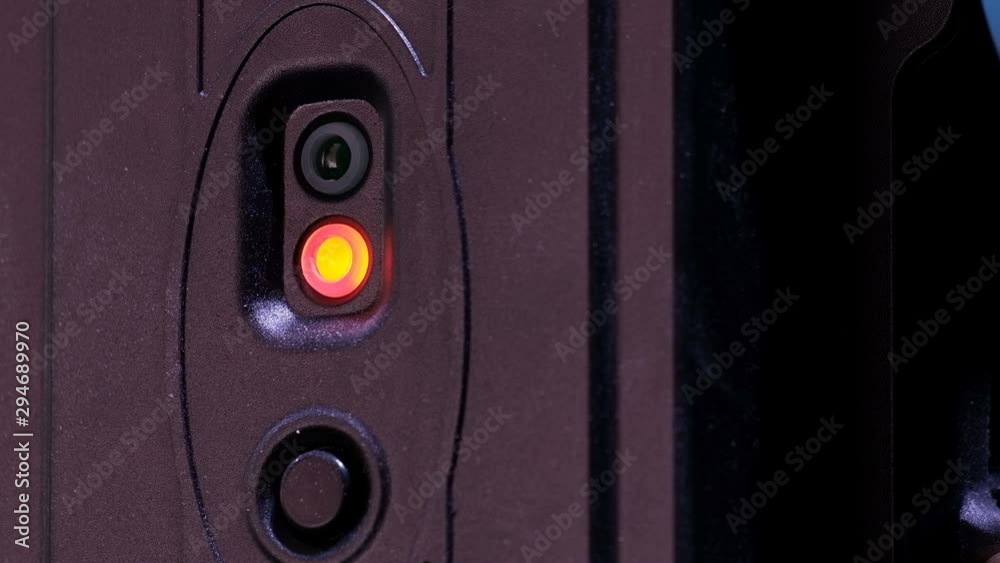 Flickering green and red light bulb. Alarm or data transmission system. Stage backstage equipment. Sensor technical device. Black background.