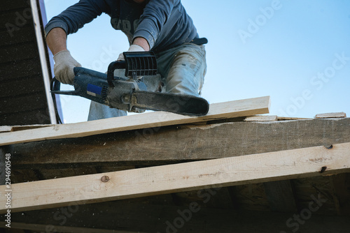 Worker is cutting a wood by a circular saw.