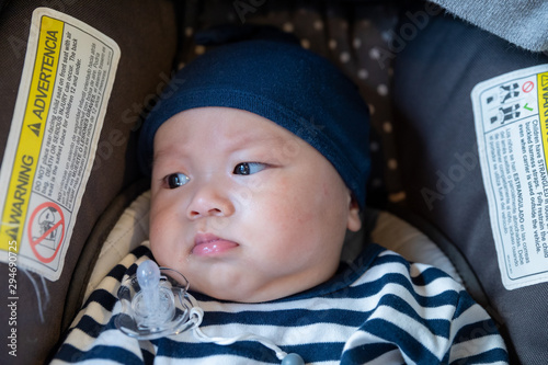 4months asian baby with Pacifier in safety car seat photo