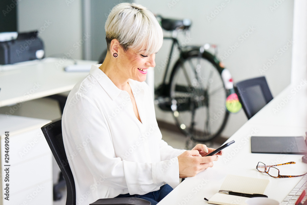 Cheerful mature businesswoman using phone Cheerful mature businesswoman using phone