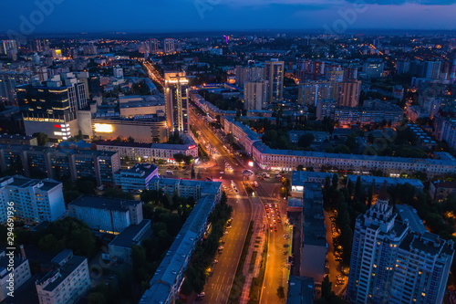 Aerial view of night city with illuminated roads  car traffic and different buildings  drone shot