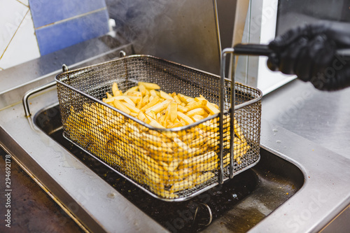 Chef Cooking French Fries at the Deep Fryer photo