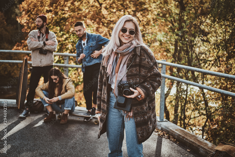 Happy smiling woman with photo camera is enjoying bright autumn day in park . Happy smiling woman with photo camera is enjoying bright autumn day in park .