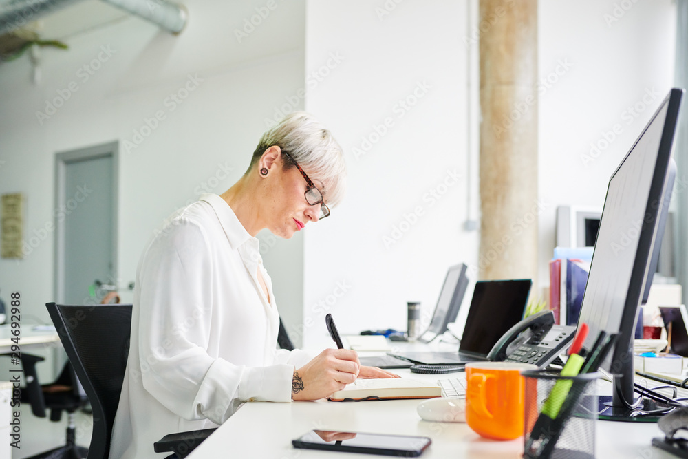 Stylish woman with notepad at desk Stylish woman with notepad at desk