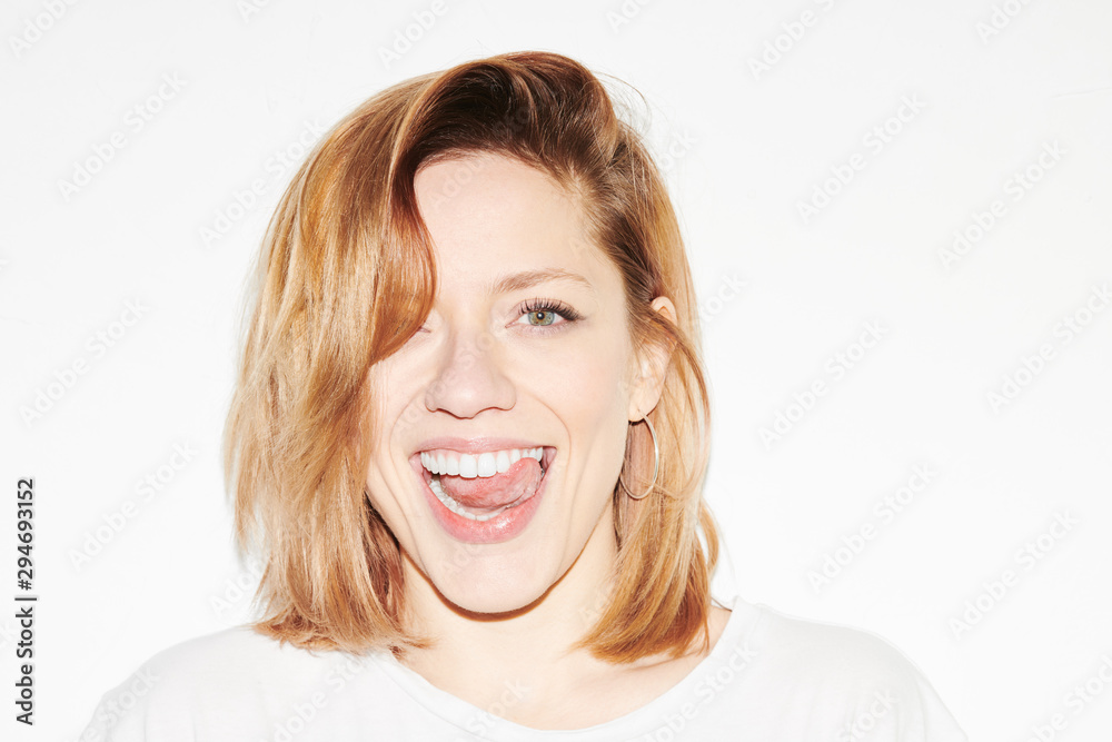 Bright young woman showing tongue playfully Bright young woman showing tongue playfully