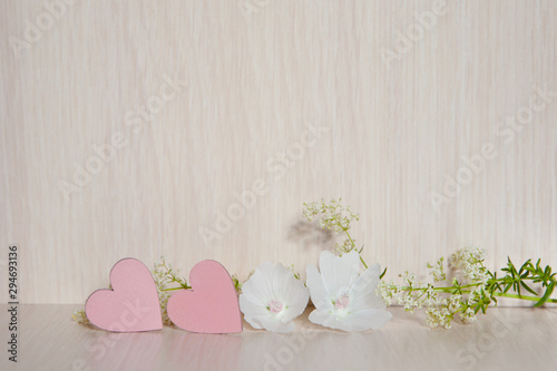 Two hearts. Background for congratulations with pink hearts. Valentine's Day. Hearts and white flower.