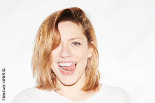 Bright young woman showing tongue playfully