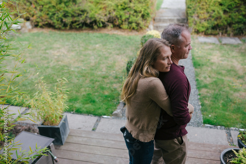 Serious couple hugging together at home.