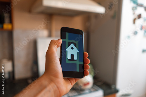 hand holding a smartphone with smart home application, modern technology
