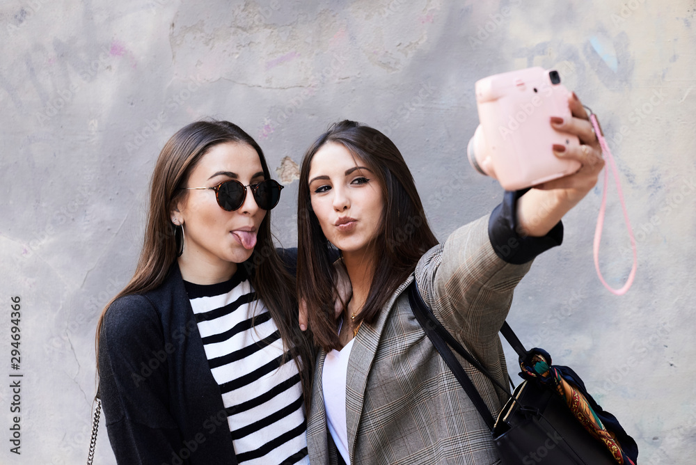 Sisters funny faces selfie with polaroid. Stock Photo | Adobe Stock