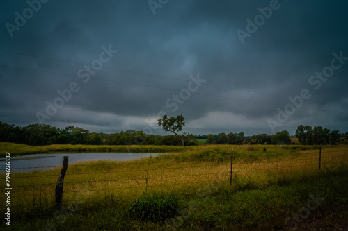 Farm pond in pasture under dark skies