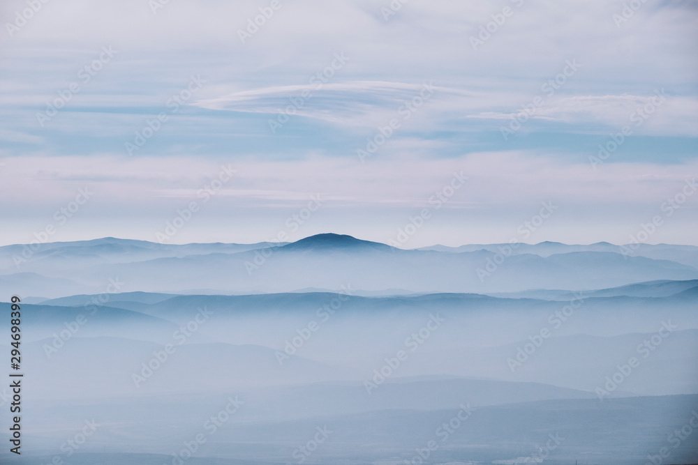 Layered mountain landscape with clouds and fog