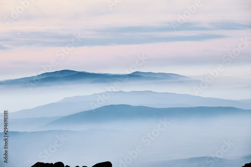 Layered mountain landscape with clouds and fog