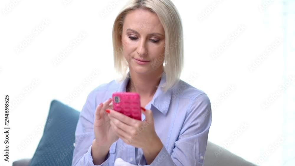 Adult woman relaxing at home and using smartphone Adult woman relaxing at home and using smartphone