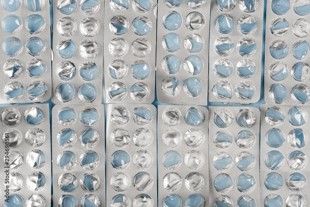 Empty blister packs of tablets on a blue background