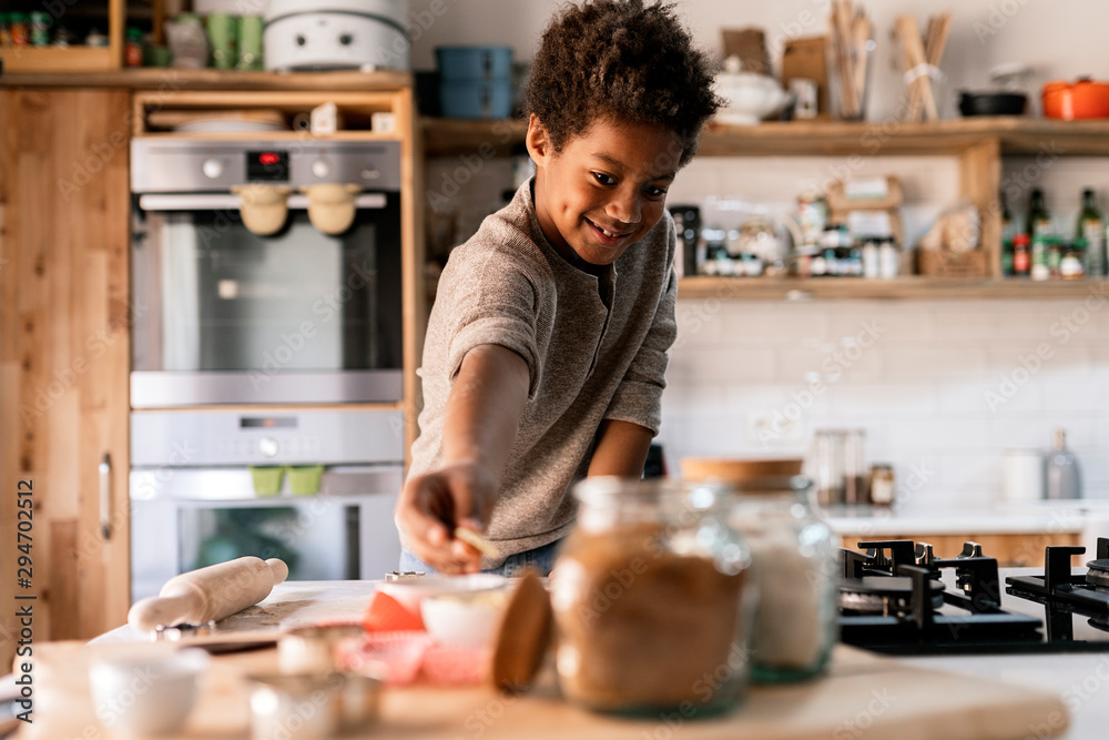 Happy black child with biscuit in kitchen Happy black child with biscuit in kitchen