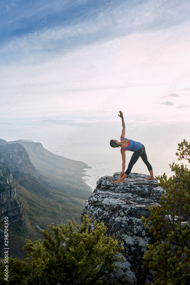 Fit female hiker doing yoga in the mountains Fit female hiker doing yoga in the mountains