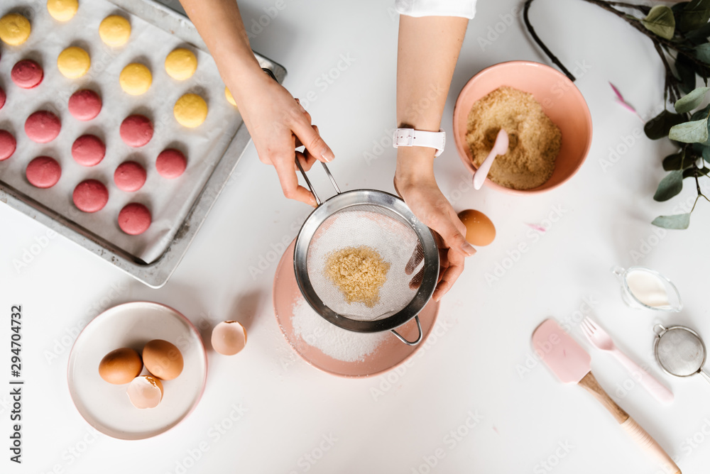 Crop hands sieving almond powder for macarons Crop hands sieving almond powder for macarons