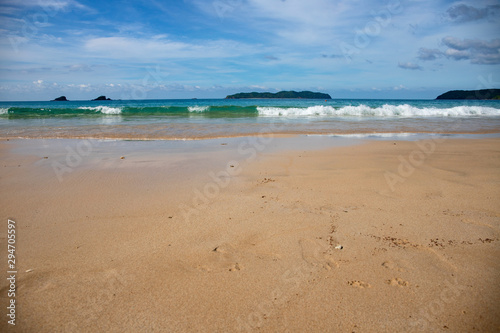 Beach sand and sea wave perspective view. Idyllic seashore with white sand beach. Tropical vacation on exotic island