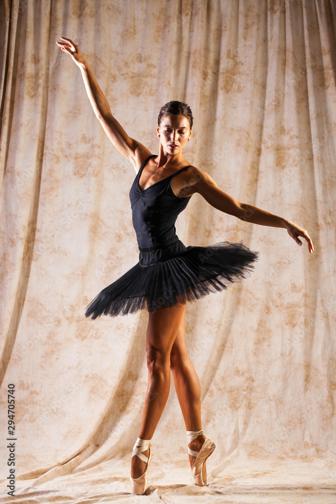 Full body portrait. Russian ballerina in a black dancing suit is posing in  dark studio Stock Photo | Adobe Stock