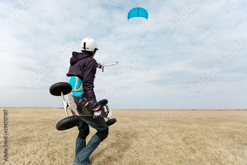 Kiteboarder holding mountainboard and a kite photo